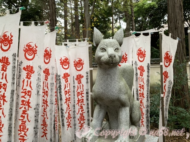 豊川稲荷（愛知県豊川市）きつね塚への参道、のぼりの数々ときつねの石像